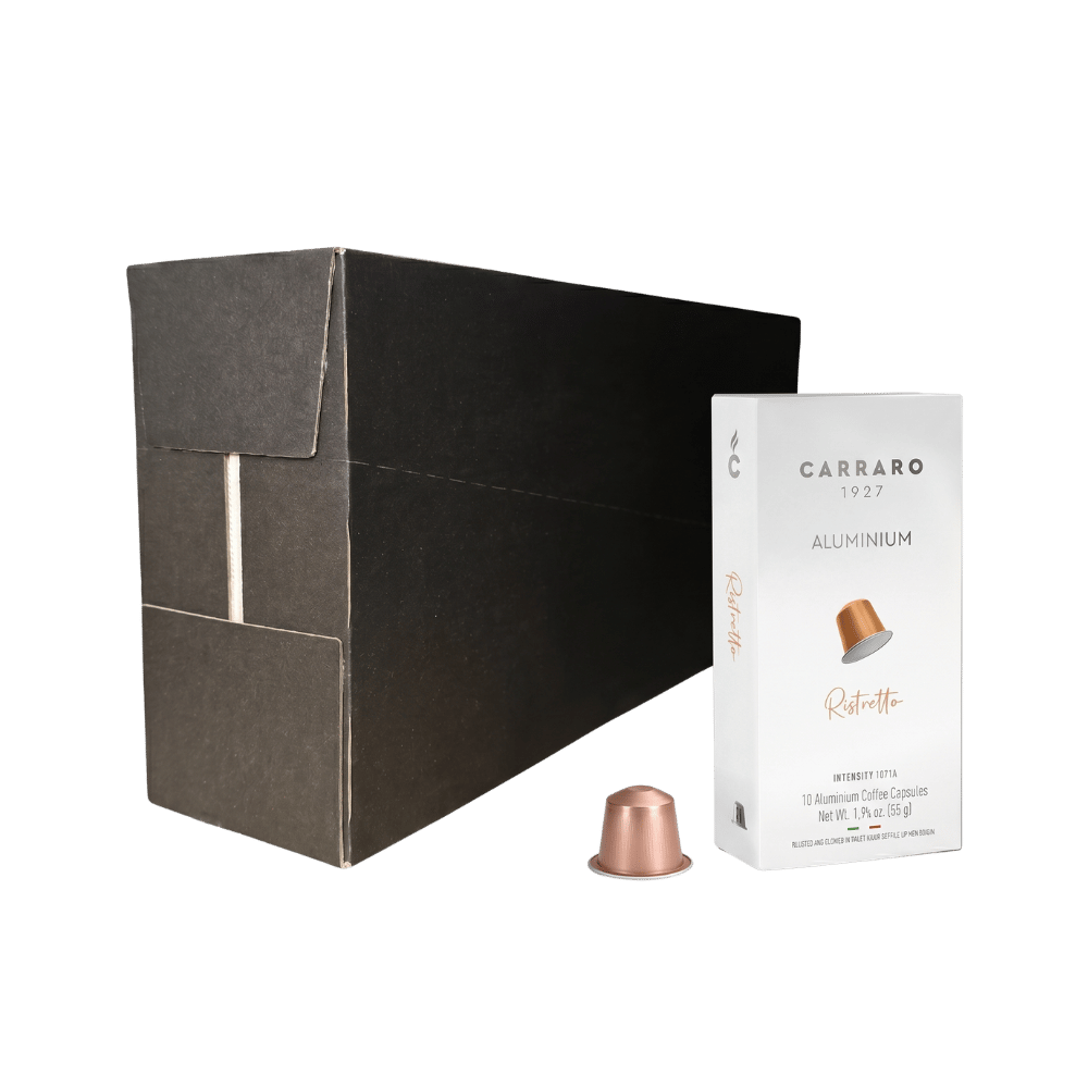 Carraro 1923 aluminium ristretto coffee capsules shown with a large black cardboard box, a white capsule box labeled 'ristretto', and one copper-colored capsule on a plain white background.